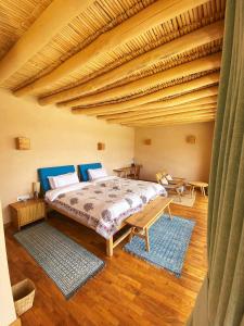 1 dormitorio con cama y techo de madera en The Indus River Camp, en Leh