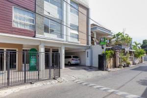 a white van parked in front of a building at Urbanview Erga Family Residence Syariah Surabaya by RedDoorz in Surabaya +10 photos