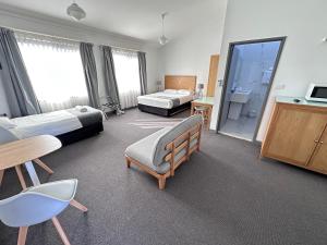 Habitación de hotel con 2 camas y baño en Spa Village Travel Inn, en Moree