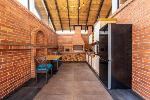 a kitchen with a brick wall and a table and chairs at Ellys Residence in Voroneţ