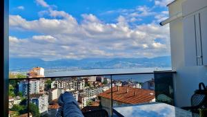 a person standing on a balcony looking out at the city at Amazing Sea & Mountain Duplex in Izmit in Izmit