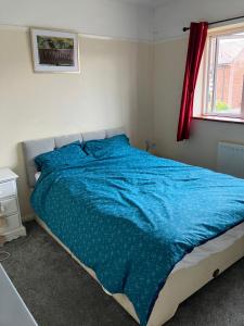 Comfortable rooms upstairs at number 8 : سرير مع لحاف أزرق في غرفة النوم