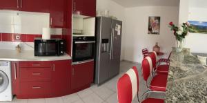 a kitchen with red cabinets and red chairs at Dyna 2 bedroom house in Sainte-Rose