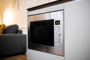 a microwave oven sitting next to a couch at Charming 60m2 One-Bedroom Apartment - WE39B in Tiel