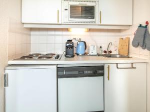 cocina con armarios blancos y fogones en T Du Morel - A25 - 4 PERS en Doucy