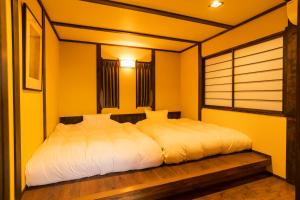 a bedroom with a large bed with white sheets at 料理の宿　伊豆の花 in Ito