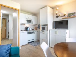 uma pequena cozinha com armários brancos e uma mesa em T Du Morel - A25 - 4 PERS em Doucy