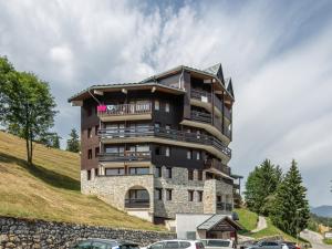 un edificio en una colina con coches estacionados frente a él en T Du Morel - A25 - 4 PERS en Doucy