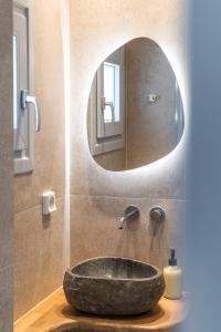 a bathroom with a stone sink and a mirror at Disis Residence in Naxos Chora