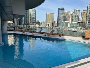 a large swimming pool with a view of a city at White Sage - Marina Gem, Fancy Apartment with Waterfront Views in Dubai