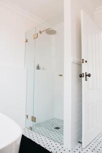 uma casa de banho com um chuveiro e uma porta de vidro em The Settler - Boutique cottage em Dubbo