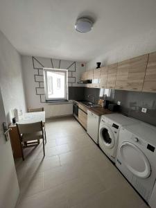 uma cozinha com uma máquina de lavar roupa e uma mesa em Übernachtung by Tag em Kassel