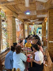 een groep mensen die aan tafel zitten in een restaurant bij Mai Chau Moonlight Ecohouse in Mai Chau