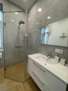 a bathroom with a glass shower and a sink at Picturesque Old Town Apartment with Charming Balcony in Kaunas