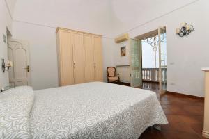 una camera con un letto bianco e una sedia di Villa Sunshine Positano Room a Positano