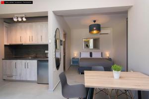 a kitchen and a bedroom with a bed and a table at Charisma Luxury Suite & Rooms in Pérdika