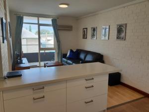 a kitchen and living room with a couch and a table at Cappuccino Delight - 1 bedroom central Fremantle apartment in Fremantle