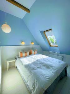 ein blaues Zimmer mit einem Bett und einem Fenster in der Unterkunft Egn Boutique Hotel in Stege