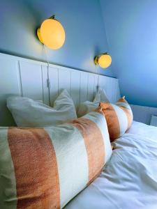 ein Bett mit Kissen und zwei Lampen darüber in der Unterkunft Egn Boutique Hotel in Stege