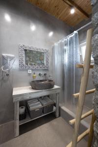La salle de bains est pourvue d'un lavabo et d'une douche. dans l'établissement OLIVES seaside villas (4elies), à Plaka