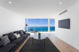 a living room with a black couch and a tv at Southpoint in Wye River
