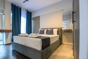 sypialnia z dużym łóżkiem z niebieskimi zasłonami w obiekcie Luxury super central apartment 1 w mieście Larisa
