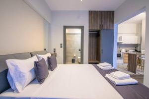 een slaapkamer met een groot wit bed met kussens bij Luxury super central apartment 1 in Larisa