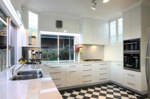 een keuken met witte kasten en een geruite vloer bij Out of the Blue - Busselton in Busselton