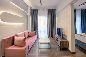 a living room with a couch and a television at Luxury super central apartment 1 in Larisa