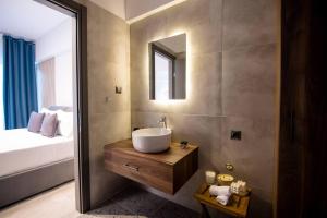 bagno con lavandino, letto e specchio di Luxury super central apartment 1 a Larisa