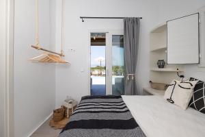 a bedroom with a bed and a sliding glass door at OLIVES seaside villas (4elies) in Plaka