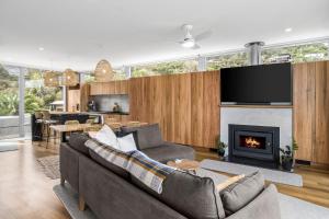 a living room with a couch and a fireplace at Six Degrees - beach across the road in Wye River