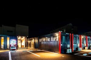 a row of metal containers in a parking lot at night at HOTEL R9 The Yard Togane in Tōgane