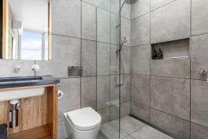 a bathroom with a shower and a toilet and a sink at Six Degrees - beach across the road in Wye River +12 photos