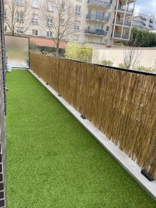a garden with a wooden fence and green grass at Magnifique appartement 3 pièces à Vitry-sur-seine (15min de Paris) in Vitry-sur-Seine
