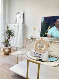 una sala de estar con una mesa con un letrero de Chanel en Magnifique appartement 3 pièces à Vitry-sur-seine (15min de Paris) en Vitry-sur-Seine