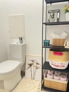 a bathroom with a toilet and a shelf with toiletries at Magnifique appartement 3 pièces à Vitry-sur-seine (15min de Paris) in Vitry-sur-Seine