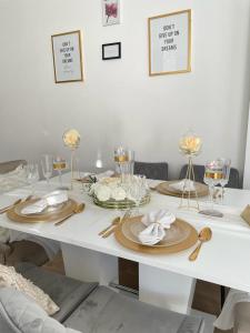 una mesa blanca con platos y copas de vino. en Magnifique appartement 3 pièces à Vitry-sur-seine (15min de Paris) en Vitry-sur-Seine