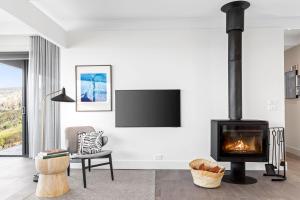 a living room with a fireplace and a tv at The Headland Retreat in Wye River