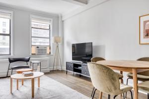 a living room with a table and a tv at UWS 2BR w Elevator Doorman Gym nr 1 line NYC-625 in New York