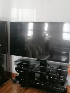 a large flat screen tv sitting on a entertainment center at FBS Homestay in Norwood