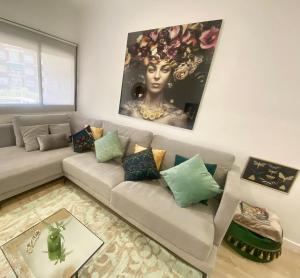 a living room with a couch and a painting on the wall at Barcelona New Apartment- Free Parking- 10 min by metro from BCN Center and Sagrada Família in Barcelona