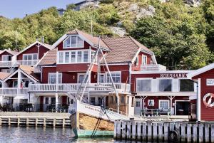 a boat is docked in front of a house at Korshamn Rorbuer in Lyngdal