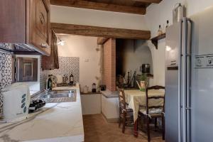 Il comprend une cuisine équipée d'un réfrigérateur et d'une table avec des chaises. dans l'établissement Il Castello di Mangona, à Barberino di Mugello