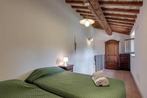- une chambre avec un lit vert et des serviettes dans l'établissement Il Castello di Mangona, à Barberino di Mugello