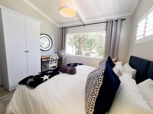ein Schlafzimmer mit einem Bett mit Kissen und einem Fenster in der Unterkunft Victoria's Secret in Kenton on Sea