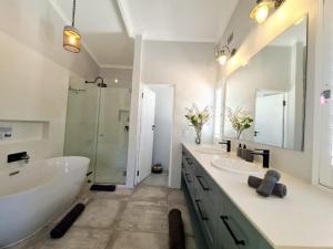 a bathroom with two sinks and a tub and a shower at Victoria's Secret in Kenton on Sea