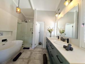 a bathroom with two sinks and a tub and a shower at Victoria's Place in Kenton on Sea +15 photos