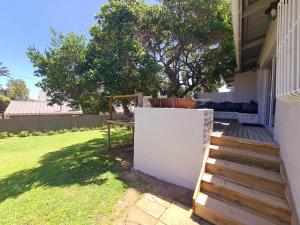 a backyard with a white fence and a wooden staircase at Victoria's Secret in Kenton on Sea