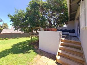 a backyard with a white fence and a wooden staircase at Victoria's Place in Kenton on Sea